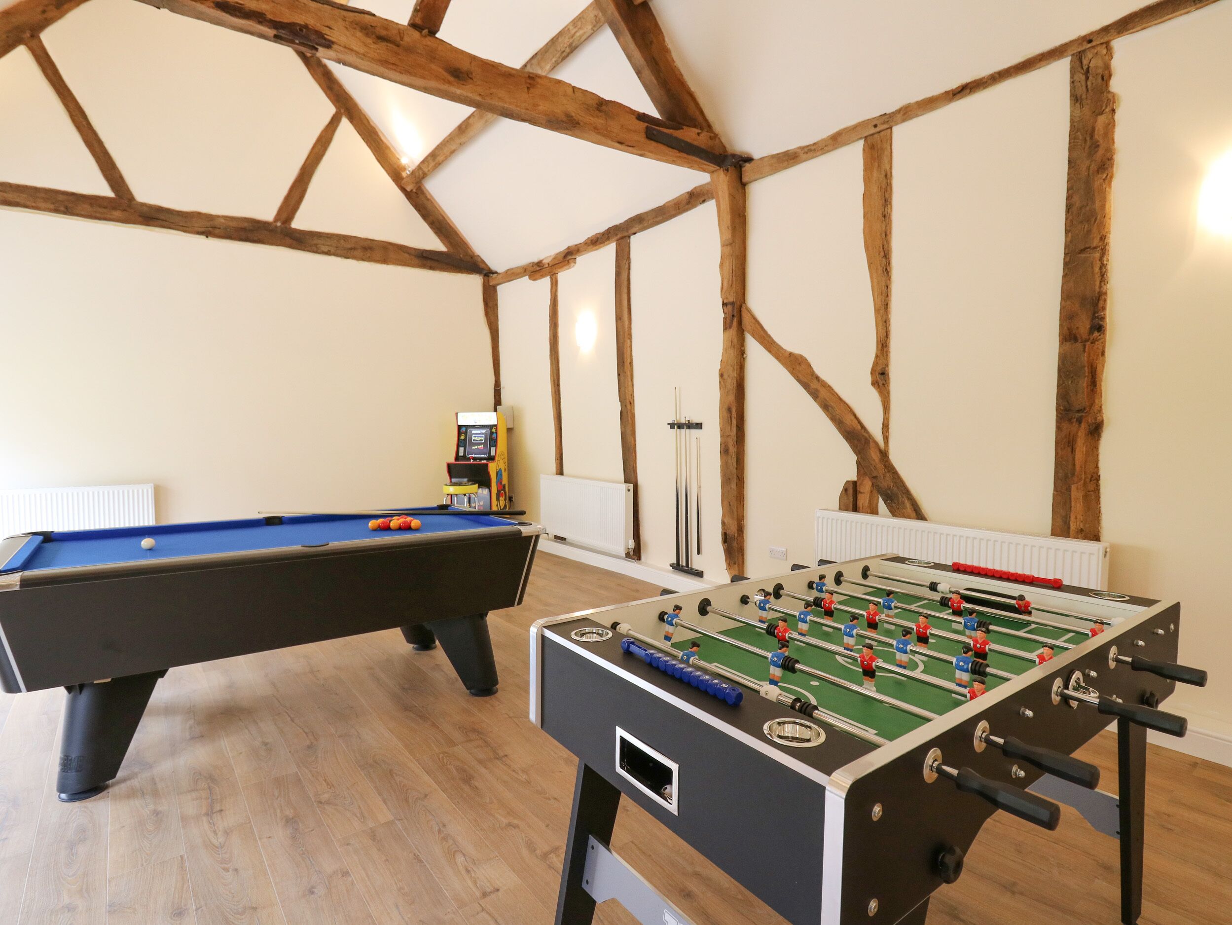 Une pièce équipée d’une table de billard, d’un baby-foot et d’un jeu de fléchettes.