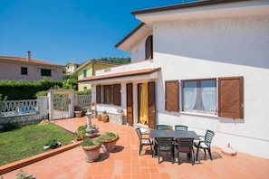 A house with a patio, outdoor seating, and potted plants. - JOIVY Shared Villa Nature&relax (Massarosa)