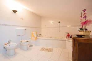 A bathroom with a toilet, bidet, bathtub, and sink. - JOIVY Shared Villa Nature&relax (Massarosa)