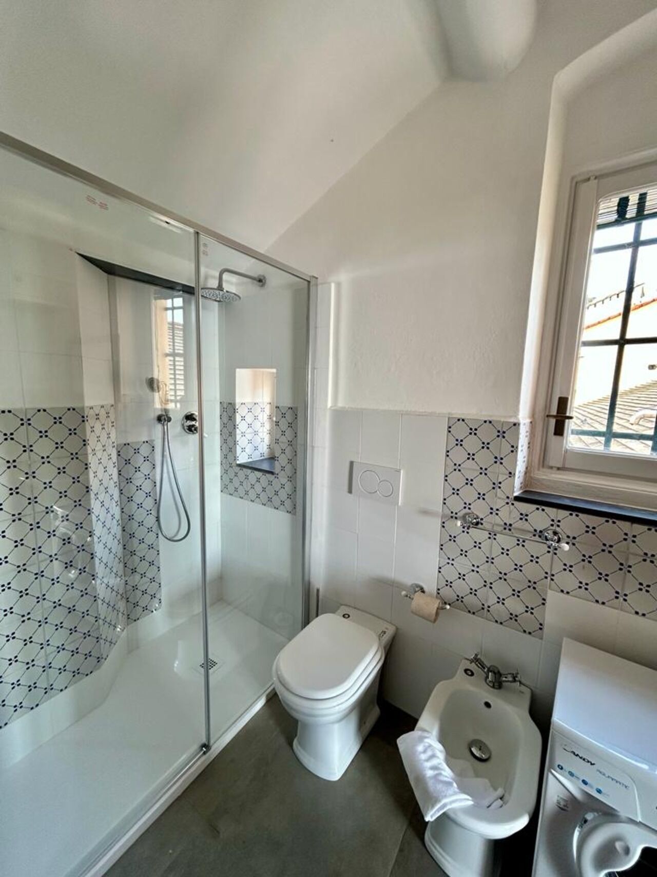 Un bagno con doccia vetrata, un water, un bidet e un lavandino.