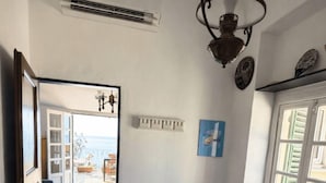 A hotel room with a bed, a window, a door leading to a balcony, and a ceiling fan. - JOIVY Camogli il Terrazzino e il Mare (Camogli)
