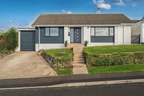 A modern two-story house with a grey door, a front yard, and a sign that reads "CHI AN MOR". - Chi An Mor (Newquay)