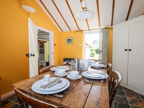 Enjoy meals in this cozy dining area with a table set for four, featuring a picture above and a radiator on the wall.