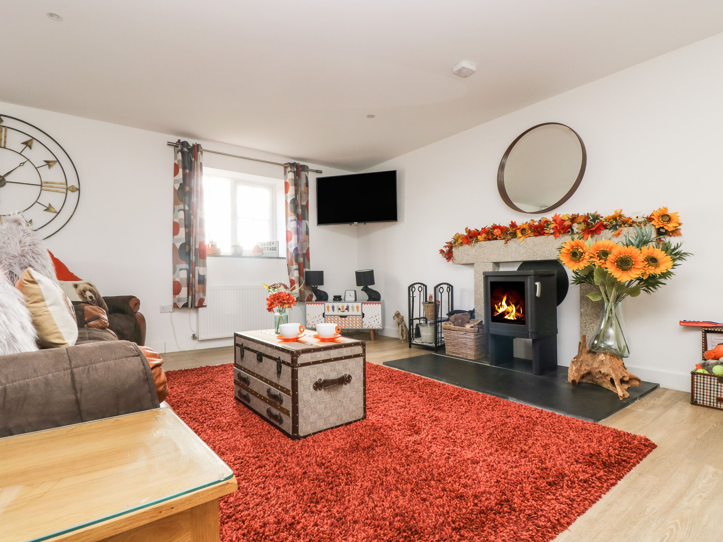 A living room with a fireplace, a sofa, a coffee table, and a red carpet.