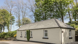 A small, single-story building with a sloped roof, a small porch, and a sign that reads "Garden Cottage." - Garden Cottage (Castle Douglas)