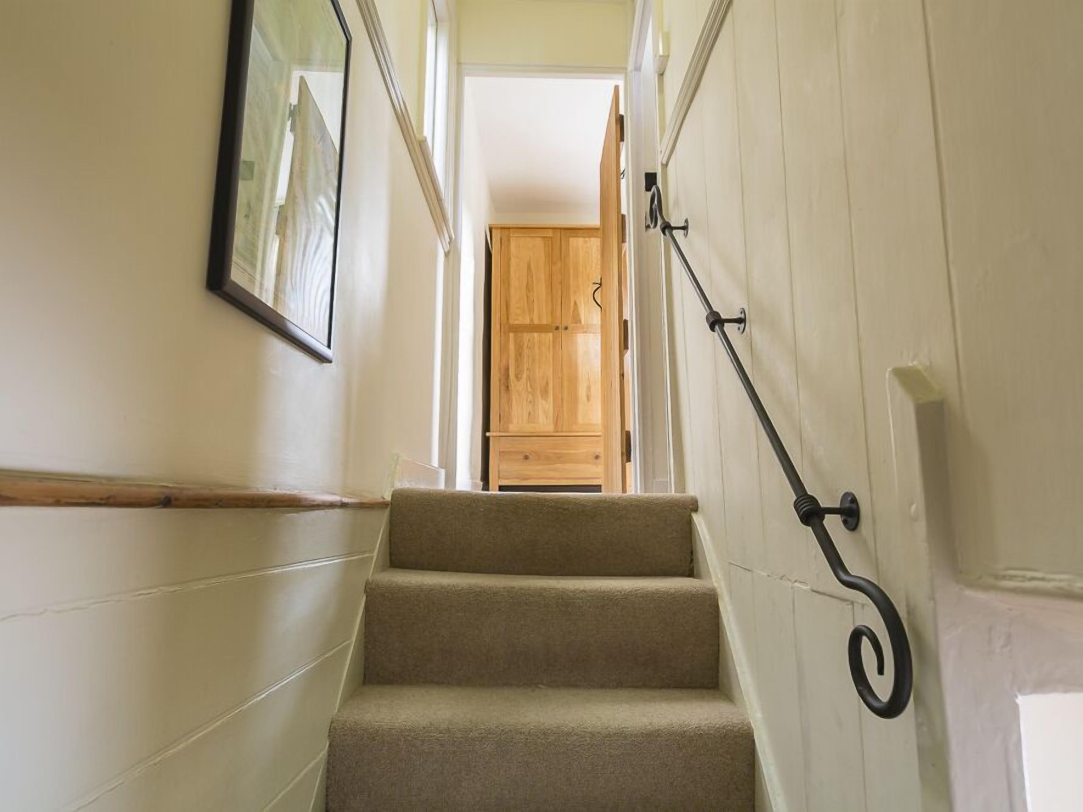 A staircase with carpeted steps leading to a wooden door.