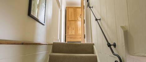 A staircase with carpeted steps leading to a wooden door.