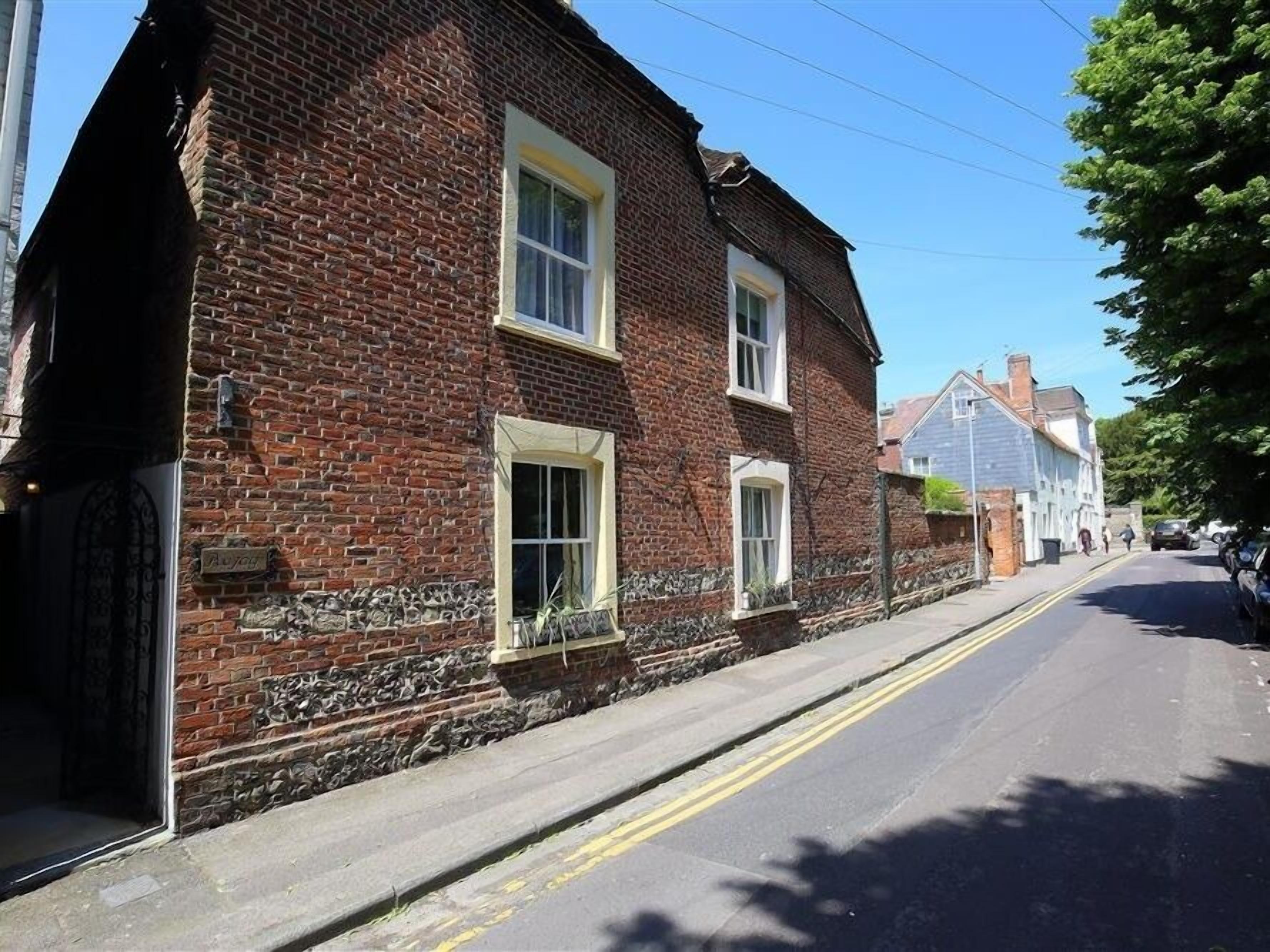 A traditional brick building with two windows and a stone foundation.
