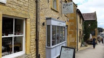 A stone building with a sign for 'The Hive' and a menu board outside.