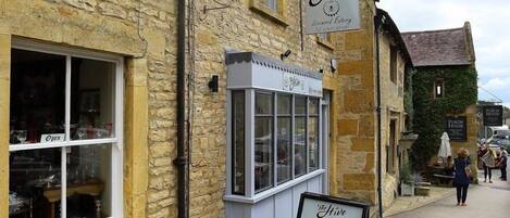 A stone building with a sign for 'The Hive' and a menu board outside.
