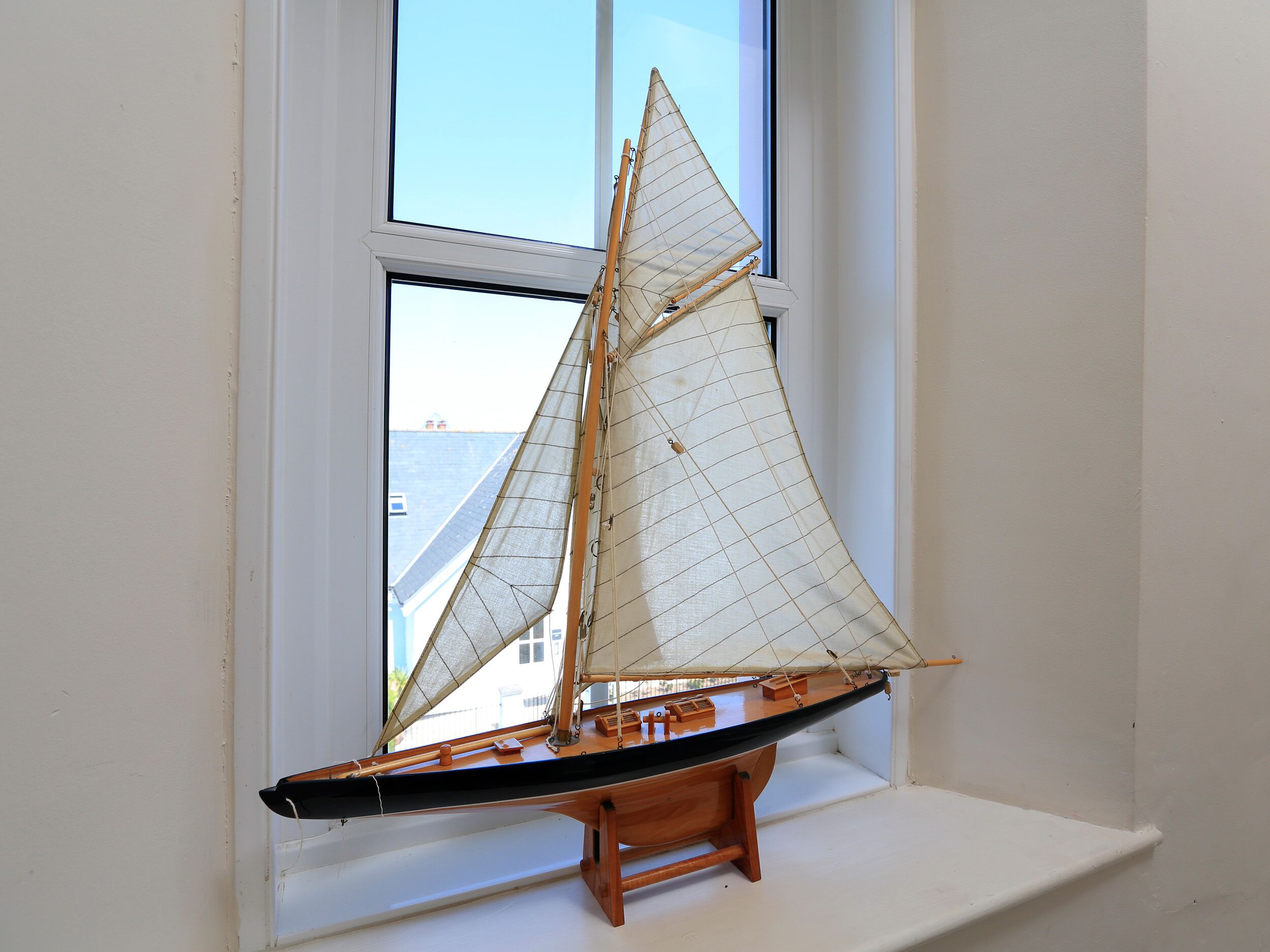 A model sailboat on a windowsill.