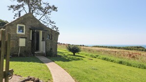 A stone cottage with a small porch, a door, and a window. - Washingpools (Dorchester)