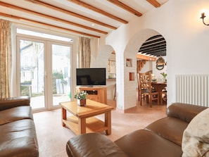 Relax in this inviting living space with a comfortable sofa, dining area, and sliding glass door leading to the outdoors.