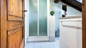 A bathroom with a wooden door, a frosted glass shower door, and a white sink. - JOIVY Big Wooden Apartment for 6 near Milano Center (Milan)