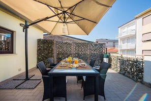 Enjoy a romantic breakfast for two in this serene outdoor dining area, complete with a shaded table setting.