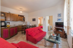 Relax in this stylish living space with a kitchen, dining area, and comfortable seating.