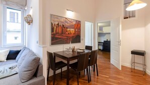 Un apartamento moderno con comedor, sofá, cocina y escalera.