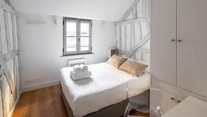 Een slaapkamer met een bed, een raam en een kledingkast.
