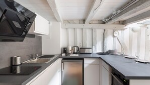Een moderne keuken met een vaatwasser, magnetron, broodrooster en spoelbak.