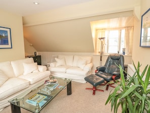 Relax in this inviting living space with a comfortable sofa, armchair, and coffee table.