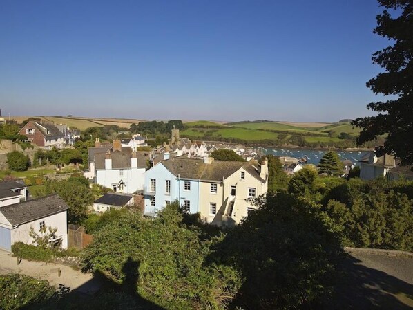 A coastal village with traditional buildings, a clear sky, and a view of the sea. - 1 Combehaven (Salcombe)