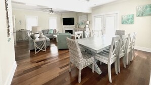 A spacious living room with a dining area, hardwood floors, and a ceiling fan. - Gated 30A Home ☀️ 6 Lots from Pool | Easy Walk to Beach ☀️Outdoor Living Area w/ TV (Santa Rosa Beach)