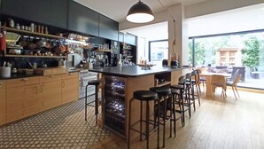 Una cocina moderna con una isla central, taburetes de bar y un ventanal con vistas al exterior.