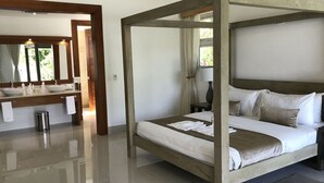 A modern bedroom with a four-poster bed, a large mirror, and a separate bathroom with a vanity. - BEAUTIFUL 3-4 BEDROOM VILLA, PRIVATE POOL, V.I.P. ACCESS $200 per night (Puerto Plata)