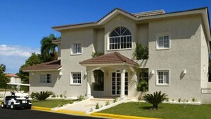 A two-story building with a central entrance, large windows, and a tiled roof. - BEAUTIFUL 3-4 BEDROOM VILLA, PRIVATE POOL, V.I.P. ACCESS $200 per night (Puerto Plata)
