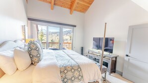 A bedroom with a bed, a TV, and a view of mountains through a large window. - Luxurious Snowmass Village 3BR Condo with Amazing Views and Hot Tub on Bus Route (Snowmass Village)