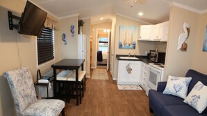 Een compacte leefruimte met een eethoek, kitchenette en zithoek.