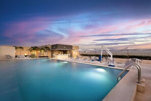 Relax by the pool surrounded by lounge chairs and umbrellas.