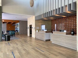 Relax in our stylish lobby, featuring a reception desk, comfortable seating area, and geometric patterned wall.