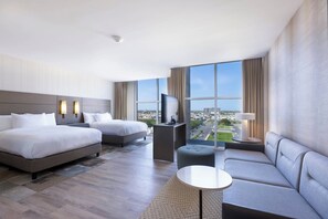 Relax in a stylish room with two beds, a sofa, and a flat-screen TV, offering a city view.
