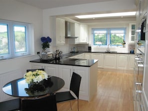 Enjoy meals in this kitchen with a central island, white cabinetry, and a dining area.