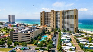 A high-rise hotel with multiple floors, a swimming pool, and a beach view. - Beach front condo at Emerald Beach Resort!! (PANAMA CITY BEACH)