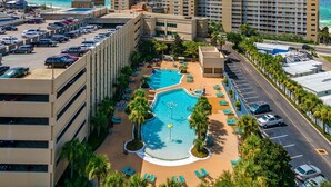 A hotel with a rooftop pool, multiple parking levels, and a view of the ocean. - Beach front condo at Emerald Beach Resort!! (PANAMA CITY BEACH)