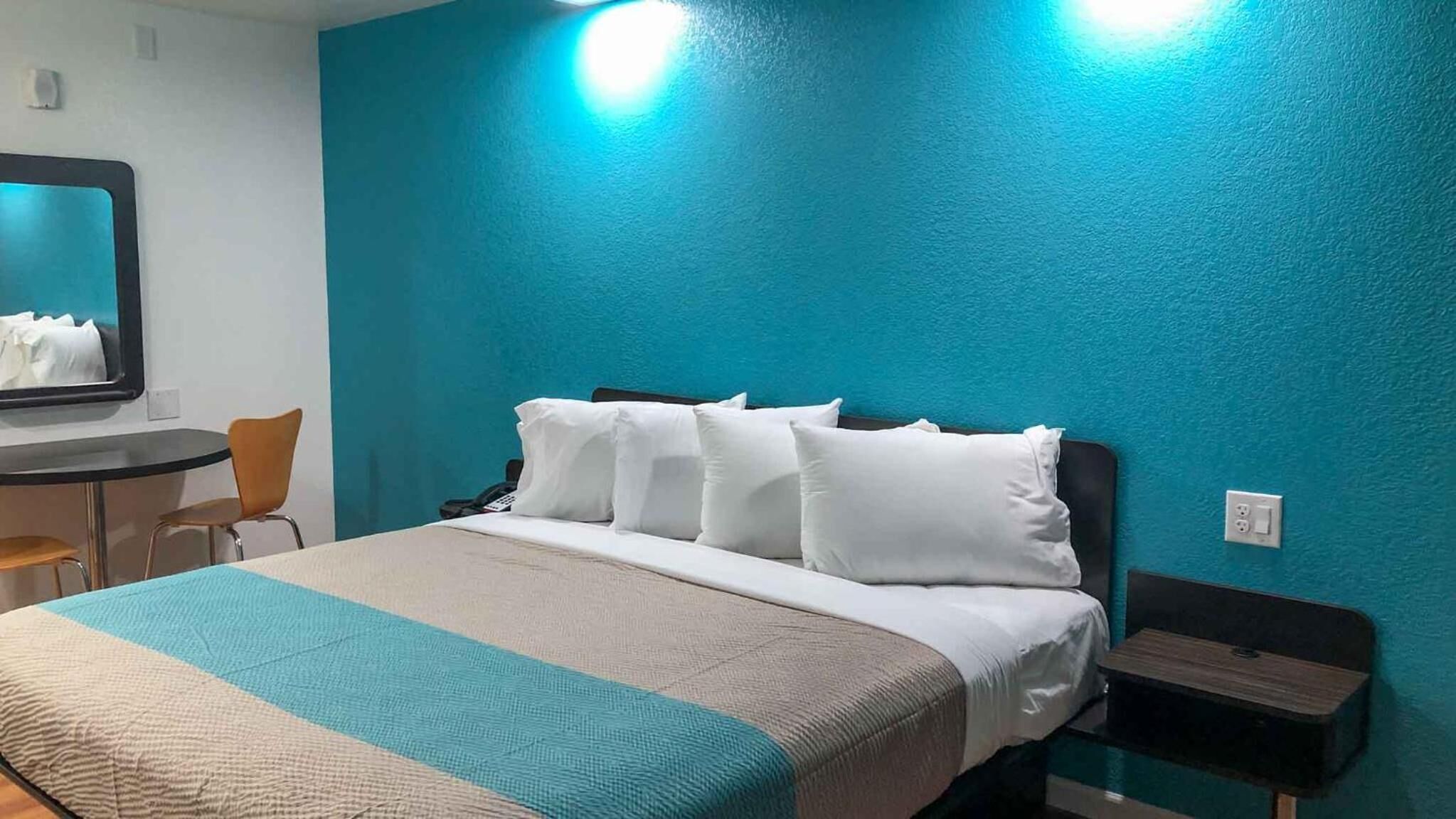 A hotel room with a bed, a desk, and a chair.