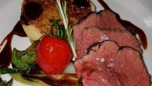 A plate with sliced meat, vegetables, and a sauce. - Gasthof Feldl (Bergkirchen)