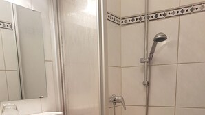 A bathroom with a sink, mirror, and shower. - Gasthof Feldl (Bergkirchen)