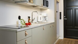 Una cocina moderna con estufa integrada, cafetera y lavamanos.