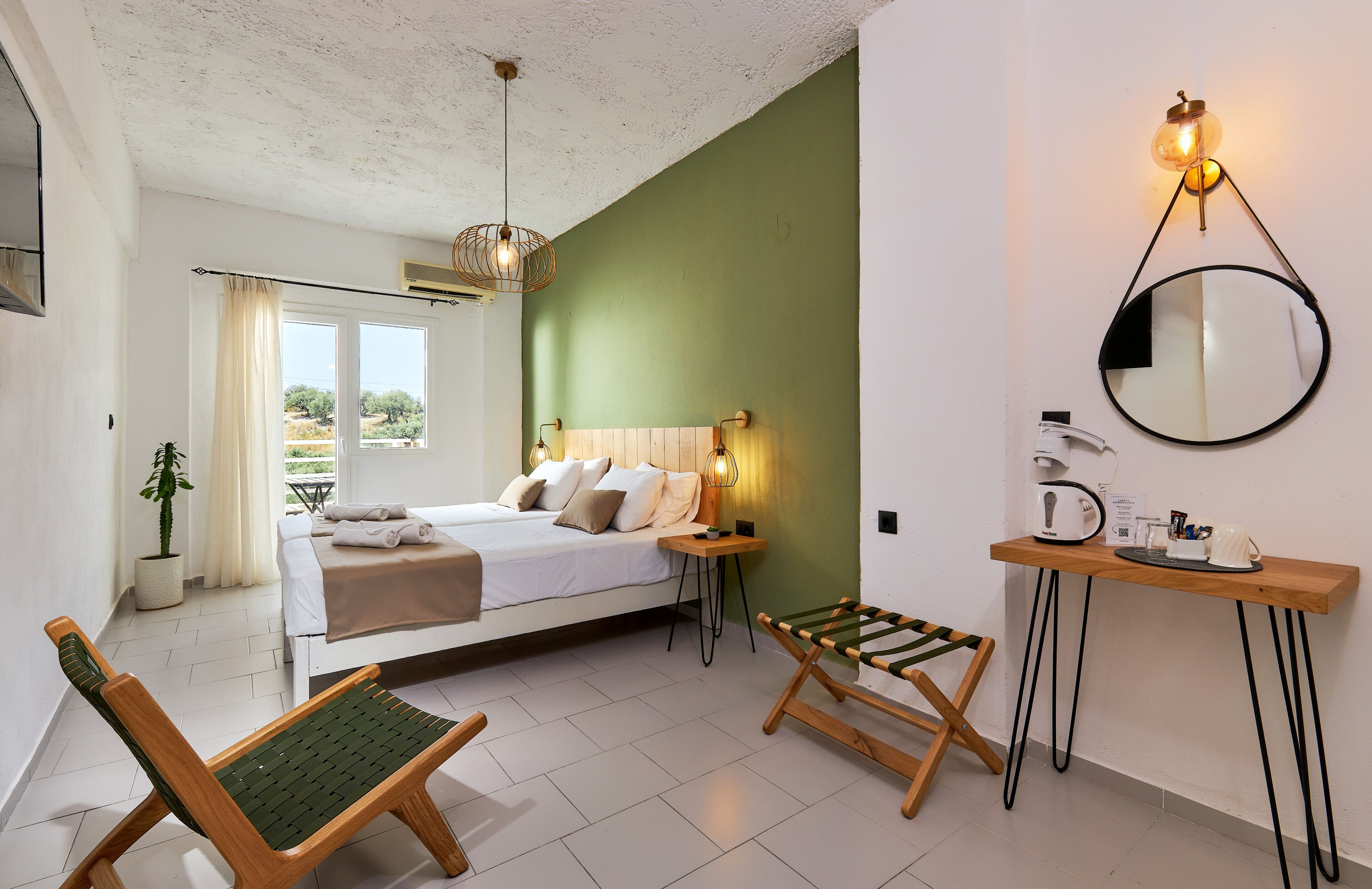 A bedroom with a bed, bedside table, lamp, and a mirror on the wall.