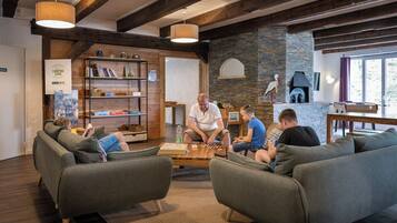 A cozy indoor setting with a fireplace, bookshelves, and comfortable seating.