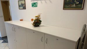 En receptionsdisk med en blomstervase, et maleri og en udgangsskilte.