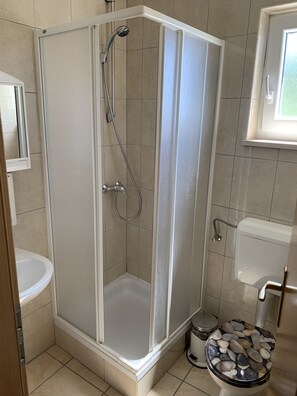 Regadera, toallas, papel de baño