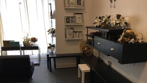A modern living room with a black sofa, a coffee table, and a bench. There are decorative items on shelves and a wall-mounted display. - Charm in the City (Baltimore)