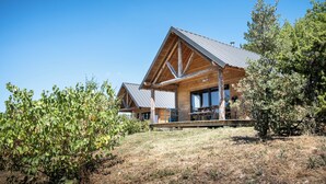 A modern log cabin with a prominent gabled roof and a covered porch. - Village Huttopia Sud Ardèche (Vagnas)