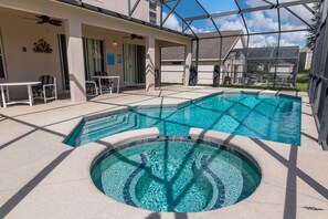 Ein Schwimmbad mit Whirlpool, Sitzgelegenheiten im Freien und einer überdachten Terrasse.