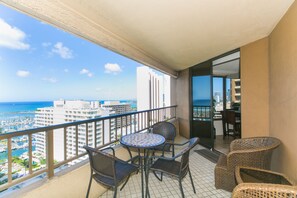 Enjoy the ocean view from this balcony with a round table and four chairs.