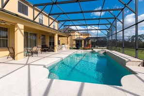 Et overdækket poolområde med terrasse, liggestole og udsigt over landskabet.